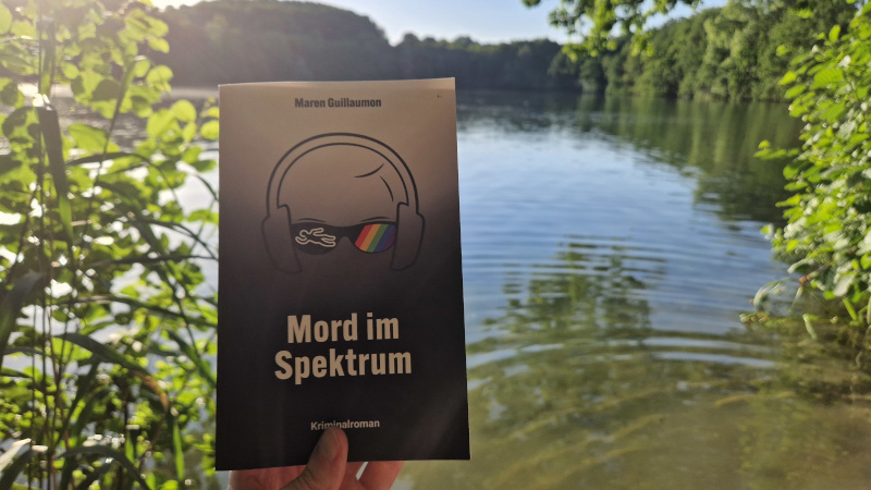 Cover vom Autismus-Krimi "Mord im Spektrum" vor einem See